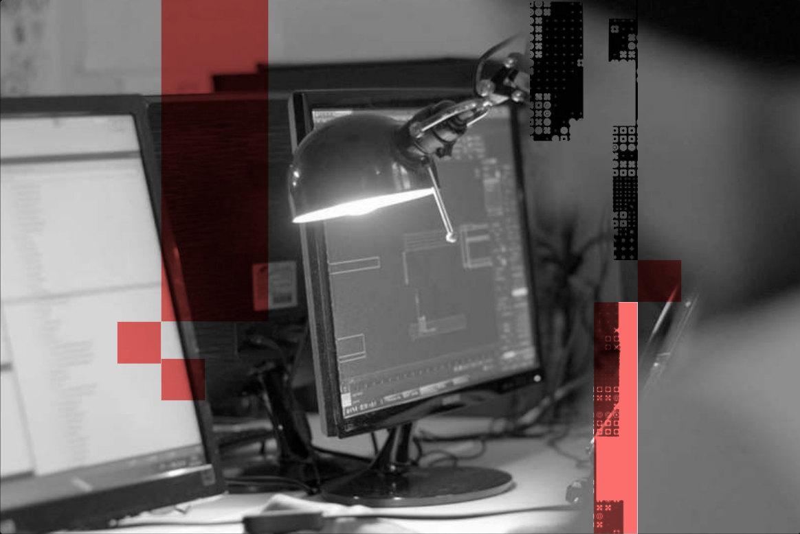 A desk lamp over a computer monitor in black and white, with coral pixel blocks